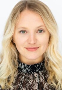 Blonde woman wearing black top smiling